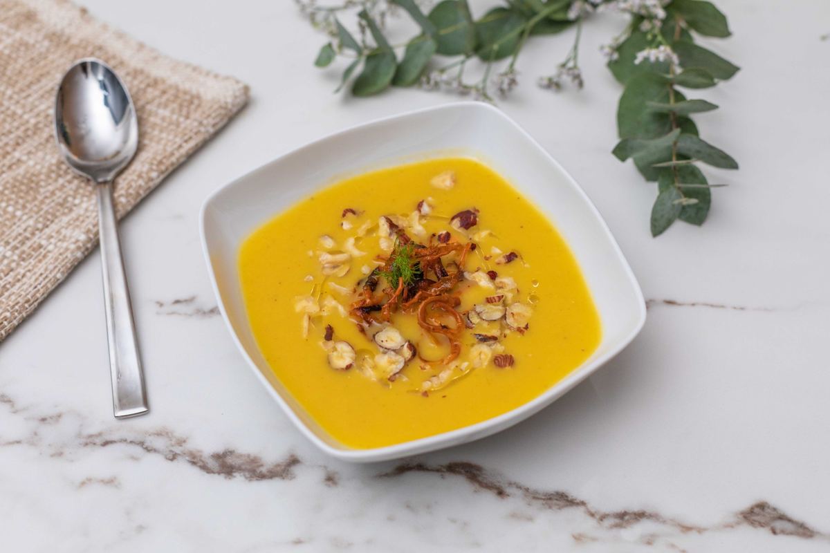 Velouté jaune garni de noisettes concassées